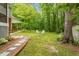 Outdoor firepit in grassy backyard with a brick-lined walkway to the home's patio at 504 S Dixon Ave, Cary, NC 27511
