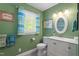Green bathroom with ample natural light, white vanity, and decorative accents at 504 S Dixon Ave, Cary, NC 27511