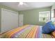 Bright and airy bedroom featuring a ceiling fan, window, and double closet at 504 S Dixon Ave, Cary, NC 27511