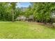 Spacious front yard with mature trees frames this brick home with a welcoming covered porch at 504 S Dixon Ave, Cary, NC 27511