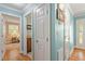 Hallway with hardwood floors, multiple doors, and a view into a bedroom and bathroom at 504 S Dixon Ave, Cary, NC 27511