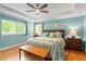 This bedroom offers natural light, a ceiling fan, wooden bench, and an en suite bathroom at 504 S Dixon Ave, Cary, NC 27511
