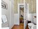 Detailed shot of bathroom featuring a vintage-style toilet, wallpaper with chair rail, and hall access, a blend of charm at 517 N East St, Raleigh, NC 27604