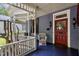 Close-up of the front porch with wicker chair and classic red door at 517 N East St, Raleigh, NC 27604