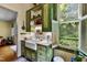 Kitchen featuring custom green cabinetry, a farmhouse sink, and stainless steel appliances at 517 N East St, Raleigh, NC 27604