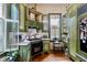 This is a cute kitchen with green cabinets, open shelving, and plenty of natural light at 517 N East St, Raleigh, NC 27604