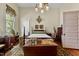 Bright main bedroom with hardwood floors, a four-poster bed, and vintage furnishings, offering a cozy and inviting atmosphere at 517 N East St, Raleigh, NC 27604