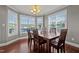 Dining room featuring a wooden table, chandelier, gray walls, white trim, and multiple windows for lots of light at 5321 Longspur Dr, Snow Camp, NC 27349