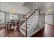 Staircase featuring hardwood stairs, white risers, and view to the living room and dining room at 5321 Longspur Dr, Snow Camp, NC 27349