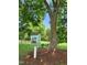 Charming little book nook under a large shade tree, featuring a bench and community library box at 6512 Blalock Forest Dr, Willow Springs, NC 27592