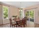 Bright dining room featuring hardwood table and chairs, large windows, and sliding glass door to the outdoor patio at 6512 Blalock Forest Dr, Willow Springs, NC 27592