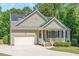 Charming home featuring a 2-car garage, solar panels and a welcoming front porch surrounded by a lush, landscaped lawn at 6512 Blalock Forest Dr, Willow Springs, NC 27592