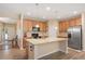 Spacious kitchen with granite island, wood cabinets, stainless steel appliances, and open access to the living area at 6512 Blalock Forest Dr, Willow Springs, NC 27592