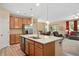 Open-concept kitchen featuring wood cabinets, stainless steel appliances, and a granite island with an eat-in bar at 6512 Blalock Forest Dr, Willow Springs, NC 27592