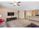 Spacious living room featuring plush sofas, a media console, and an open floor plan leading to a kitchen area at 6512 Blalock Forest Dr, Willow Springs, NC 27592