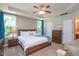 Relaxing main bedroom with a wooden bed frame, soft bedding, and natural light from large windows at 6512 Blalock Forest Dr, Willow Springs, NC 27592