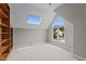 A bedroom featuring a skylight, a large window, and built in bookshelves at 6728 Pointe Vista Cir, Raleigh, NC 27615