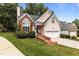Charming home featuring a two-car garage and brick accents, complemented by lush greenery at 6728 Pointe Vista Cir, Raleigh, NC 27615