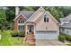Charming home featuring a two-car garage and brick accents with manicured landscaping at 6728 Pointe Vista Cir, Raleigh, NC 27615