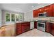 Modern kitchen with stainless steel appliances, granite countertops, and dark wood cabinetry at 6728 Pointe Vista Cir, Raleigh, NC 27615