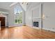 Spacious living room with hardwood floors, fireplace, and large windows overlooking the backyard at 6728 Pointe Vista Cir, Raleigh, NC 27615
