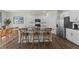 Modern kitchen with white cabinets, a large island with bar stools, and stainless steel appliances for a sleek look at 708 Comice Pear Way, Willow Springs, NC 27592