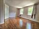 Bright bedroom with two windows and warm-toned wood-look floors at 7719 Kingsberry Ct, Raleigh, NC 27615