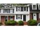 Charming two-story townhome with black shutters, brick stairs, and lush green landscaping at 7719 Kingsberry Ct, Raleigh, NC 27615