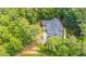 Expansive home with a large patio and lush landscaping surrounded by mature trees, perfect for serene outdoor living at 8 Pine Top Pl, Durham, NC 27705