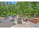 Landscaped backyard featuring a stone patio with outdoor seating and lush greenery at 8 Pine Top Pl, Durham, NC 27705