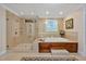 Bright bathroom featuring a glass shower, a drop-in tub with tile surround, and a decorative window at 8 Pine Top Pl, Durham, NC 27705