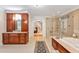 Spacious bathroom with a glass shower, a soaking tub, custom cherry cabinets, and tile flooring at 8 Pine Top Pl, Durham, NC 27705