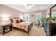 Charming bedroom with a black wrought iron bed, floral bedding, and two large windows at 8 Pine Top Pl, Durham, NC 27705