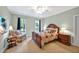 Cozy bedroom featuring a wooden bed frame, two windows with backyard views, and a comfortable armchair at 8 Pine Top Pl, Durham, NC 27705
