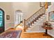 Grand foyer featuring hardwood floors, staircase with decorative railing, and elegant decor at 8 Pine Top Pl, Durham, NC 27705
