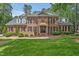 Elegant brick home with manicured lawn, black shutters, and a copper-roofed entrance at 8 Pine Top Pl, Durham, NC 27705