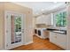 Bright laundry room featuring white cabinets, washer and dryer, sink and exterior door at 8 Pine Top Pl, Durham, NC 27705