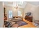 Vaulted living room with hardwood floors, a chandelier, plantation shutters, and built-in shelving at 8 Pine Top Pl, Durham, NC 27705