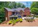 Back of a brick home with a spacious deck, screened porch, and outdoor seating area at 8 Pine Top Pl, Durham, NC 27705