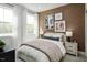 Cozy bedroom featuring a textured accent wall, plush bedding, and plenty of natural light at 1003 Regalia Rd # 33, Durham, NC 27713