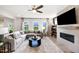 Cozy living room with a sectional sofa, fireplace with TV, and large windows overlooking the yard at 1020 Dillon Lake Dr, Knightdale, NC 27545