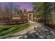 Beautiful brick home with well-manicured landscaping, long driveway, and red front door at 10210 Governors Drive Dr, Chapel Hill, NC 27517
