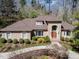 Aerial view of a brick home with an arched entryway, lovely landscaping, and a long driveway at 10210 Governors Drive Dr, Chapel Hill, NC 27517