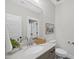 Neutral-toned bathroom featuring a toilet, vanity with white countertop, mirror, and framed picture at 1049 Coldspring Circle, Durham, NC 27705