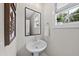 Charming powder room with a pedestal sink, neutral walls, and a window with a potted plant at 1049 Coldspring Circle, Durham, NC 27705
