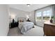 Cozy bedroom with a large window, neutral decor, carpeted floors, and stylish bedside tables at 1049 Coldspring Circle, Durham, NC 27705