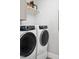 Clean and modern laundry room featuring front loading washer and dryer, shelving, and white walls at 1049 Coldspring Circle, Durham, NC 27705