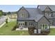Aerial view of gray home with large backyard, patio with outdoor seating, and manicured landscaping at 1049 Coldspring Circle, Durham, NC 27705