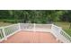 Inviting back deck with white railing and a stone picnic table beneath the shade trees at 107 Oak Park Dr, Benson, NC 27504