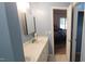 Bathroom with double sinks, white countertops, and view into the bedroom at 107 Oak Park Dr, Benson, NC 27504